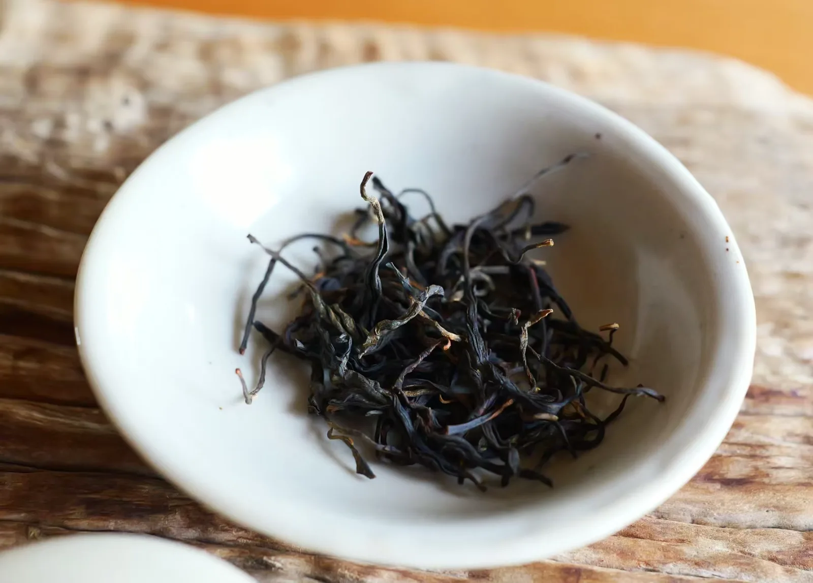 Ancestor Red, dark twisted ancient-tree red tea leaves in a white cup