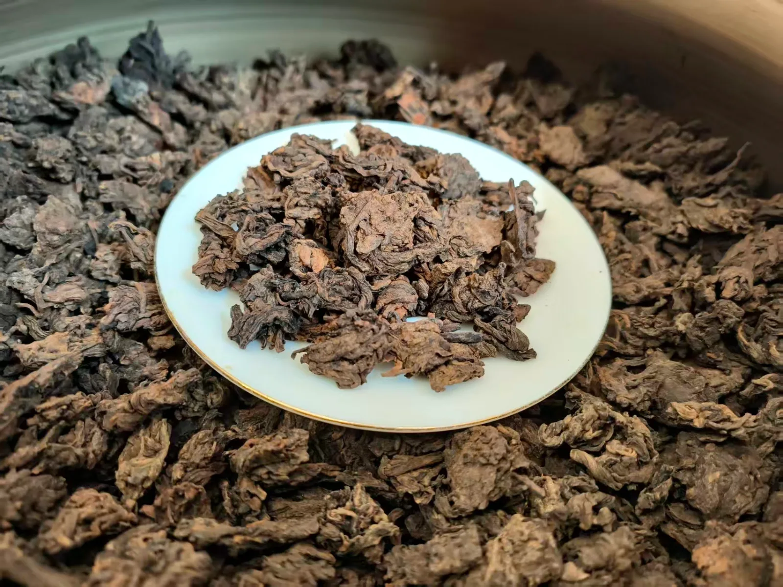 Ba Da fermentation heads, dense pu'erh leaf clusters on a white dish