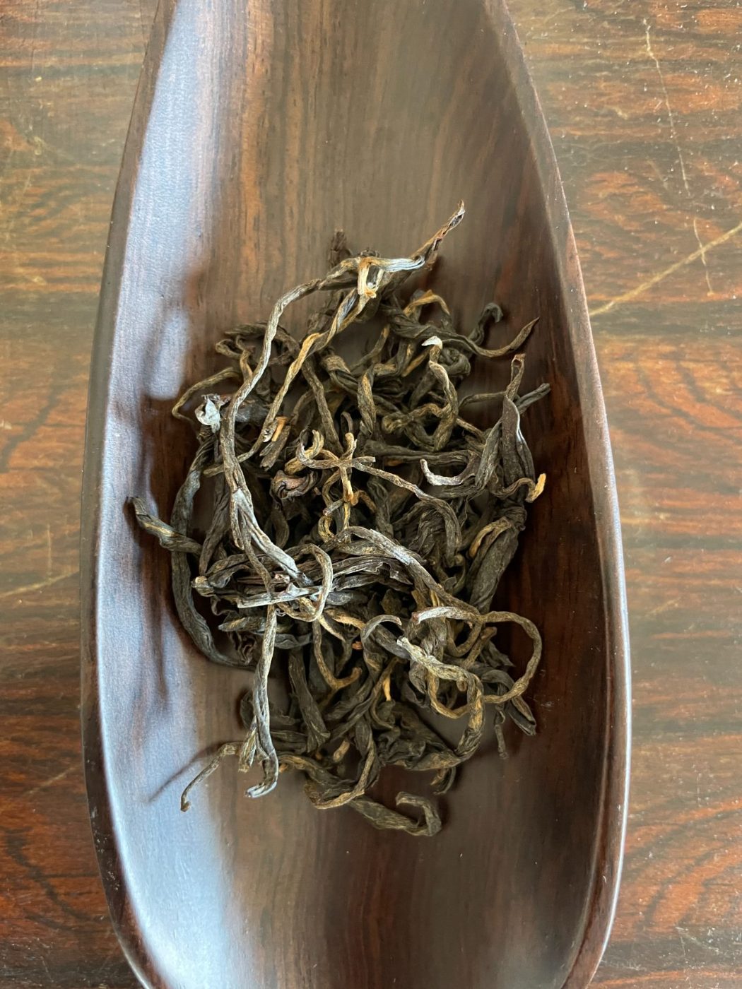 Ancestor Red, loose ancient-tree red leaves in a wooden tray
