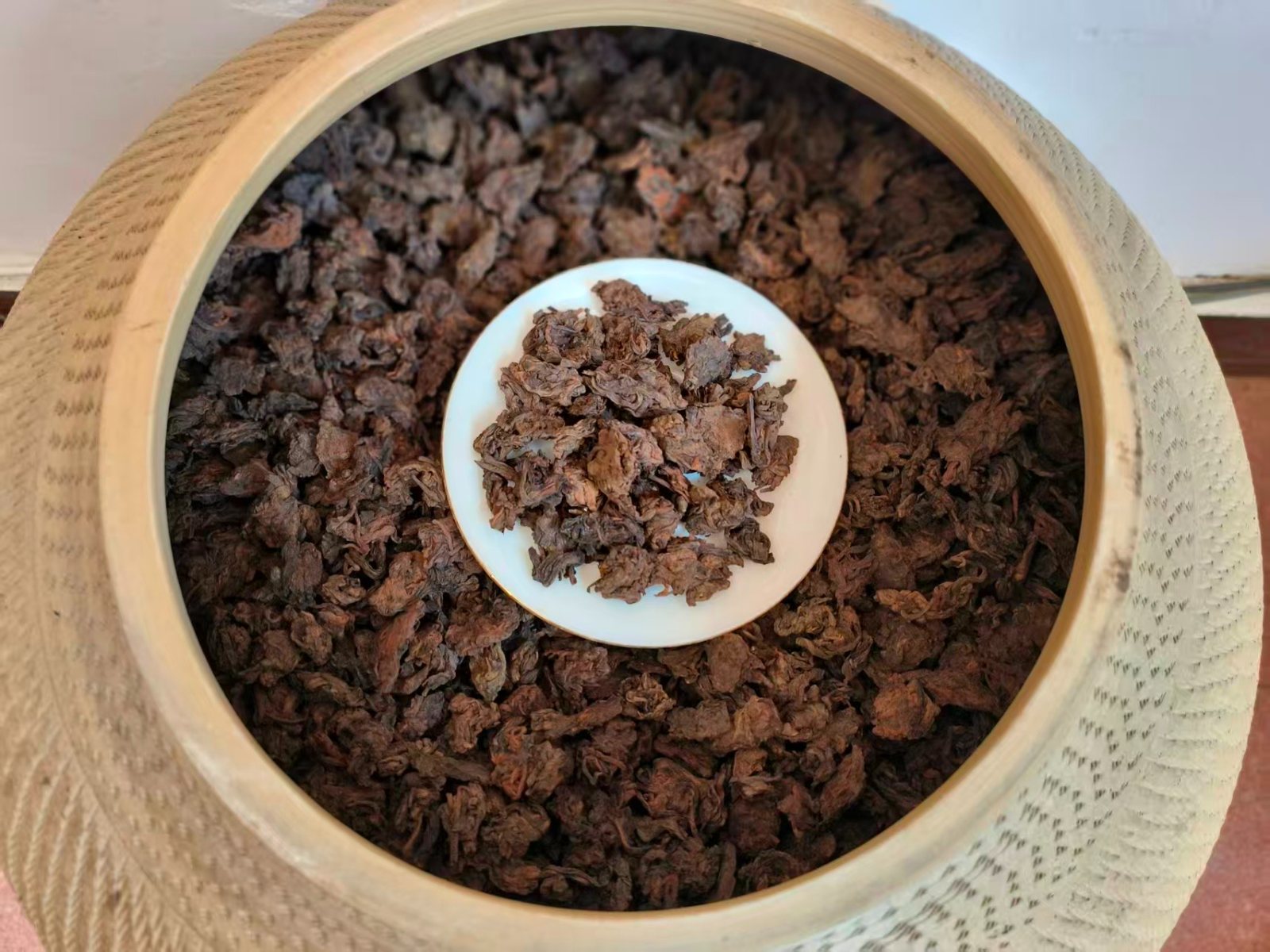 Ba Da fermentation heads, dense pu'erh leaf clusters on a white dish